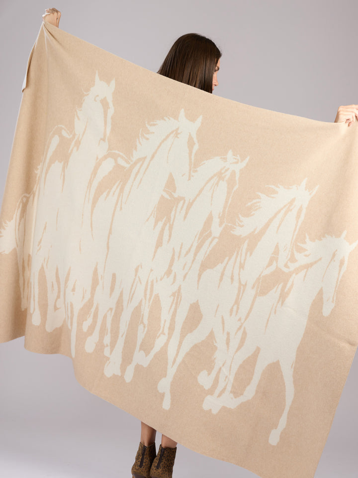 A rectangular cashmere blanket featuring a stylized silhouette of a herd of horses in motion, rendered in a muted oat on a warm pearl background #PEARL/OAT